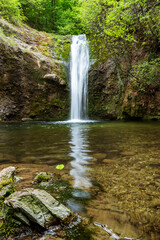 Picturesque view of Swallows Waterfall or lyastovichi vir, lagoon and fresh green of forest in Rhodope Mountains, Balkan Peninsula. Destination for hiking and eco tourism. Beautiful nature of Bulgaria