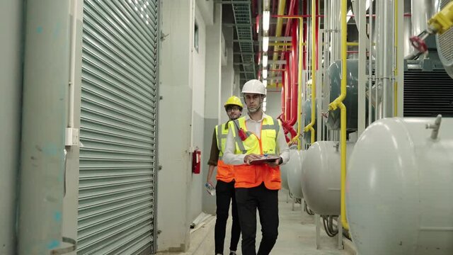 inspector, Engineer Or the foreman patrolling the boiler room in the factory
