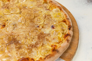 Cinnamon Banana Pizza Sweet Homemade Artesanale Close Up Detail on a Round Wooden Plate with Flour Background Table