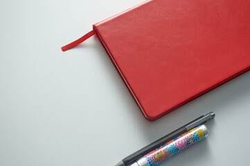 Small red notebook with colored pencil and eraser