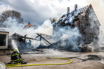 Fototapeta premium Feuerwehr löscht brennendes Haus