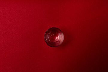 Glass of water with red background