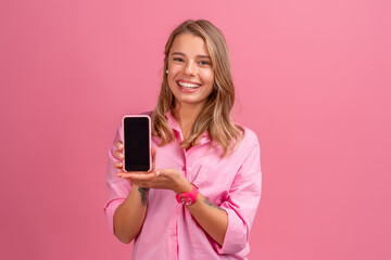 Fototapeta premium blond pretty woman in pink shirt smiling holding holding using smartphone