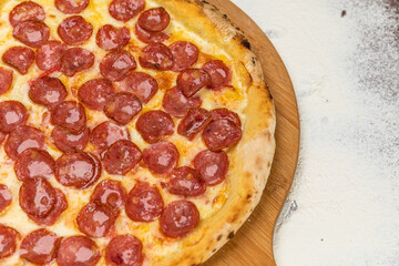 Pepperoni Pizza Homemade Artesanale Close Up Detail on a Round Wooden Plate with Flour Background Table