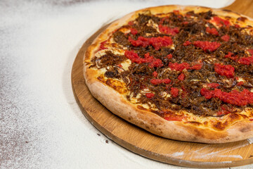 Bacon and Cheese Pizza with Rustic Tomato Sauce Homemade Artesanale Close Up Detail on a Round Wooden Plate with Flour Background Table
