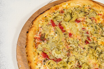 Pizza Artichoke and Cheese Homemade Artesanale Close Up Detail on a Round Wooden Plate with Flour Background Table