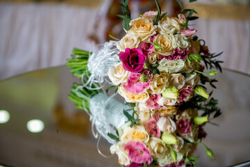 The bride's bouquet with eustoma flowers on the mirror table. Pink, white and lilac flowers.