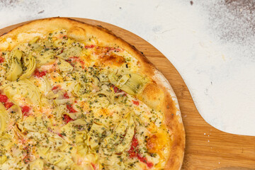 Pizza Artichoke and Cheese Homemade Artesanale Close Up Detail on a Round Wooden Plate with Flour Background Table