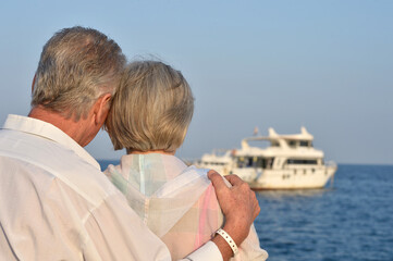 Senior couple sitting on a rock looking a sea