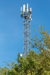 5G radio network telecommunication equipment with radio modules and smart antennas mounted on a metal on blue sky background.