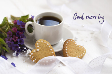 cup of coffee, heart shaped cookies, lilac spring flowers on a white background. good morning - text.