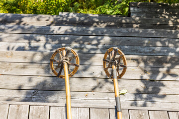 Close up view of vintage bamboo ski poles isolation on wooden background.