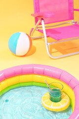 paddling pool with a lemon-shaped inflatable with a cocktail. there is a ball and a pink chair behind it.