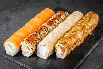 appetizing set of sushi roll on a black stone plate