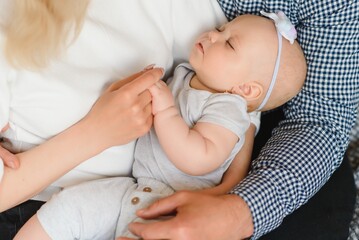 Portrait of happy young parents with baby in the bed at home