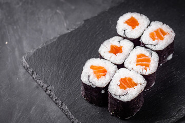 appetizing sushi roll maki with salmon on a black stone plate © Narsil