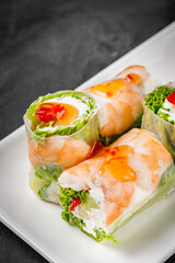 appetizing spring rolls with sea food and philadelphia cheese on a darck background
