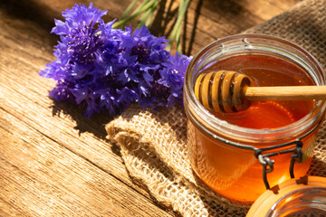 Obraz na płótnie Canvas a jar of honey and honey dipper