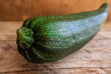Whole and raw zucchini, on a rustic wooden background. 