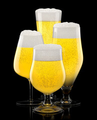 Set of fresh stout beer glasses with bubble froth isolated on black background.