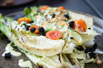 Original salad with fried lettuce leaves, cherry tomatoes, black bread croutons and dressing. Vegetarian food plate concept