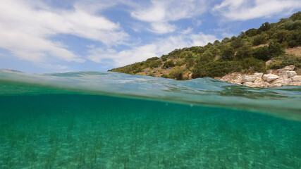 Fototapeta premium Split underwater photo of exotic Caribbean island seascape with emerald sea and beautiful clouds