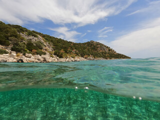 Fototapeta premium Split underwater photo of exotic Caribbean island seascape with emerald sea and beautiful clouds