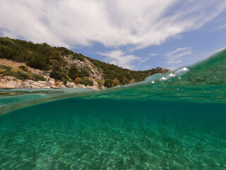Obraz premium Split underwater photo of exotic Caribbean island seascape with emerald sea and beautiful clouds
