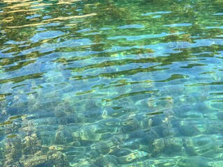 Fototapeta na wymiar Turquoise sea water surface. Crystal clear blue green rippled sea background. Clean green waters. Relax, zen, harmony, summer. Wonderful seascape of Mediterranean coast.
