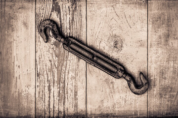 Rusty hook on old wooden table covered with blue paint. View from above