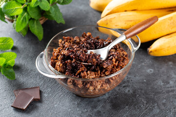 Chocolate oatmeal or oat porridge with chocolate on top served in small bowl. Selective Focus
