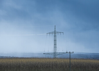 transmission tower  against sky and forest in Germany