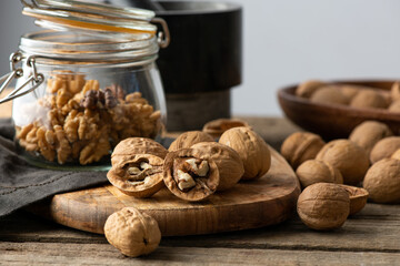 Tasty walnuts with cracked split nutshells in the jaw on rustic napkin and wood table