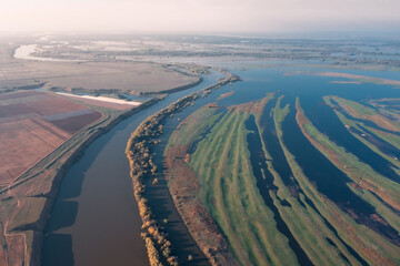 Aerial view of the Volga River in the lower reaches where the main channel splits into many small streams with green meadows between them