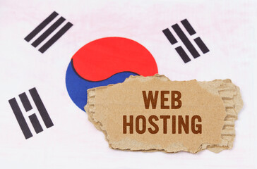 Against the background of the South Korean flag lies cardboard with the inscription - Web Hosting