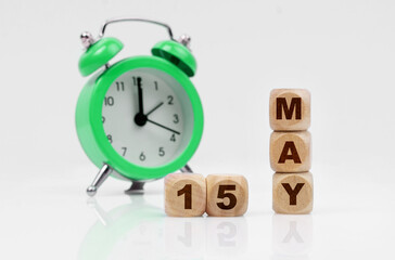 On a white background there is an alarm clock and a calendar with the inscription - MAY 15