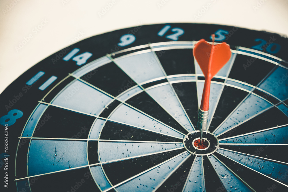 Poster close up shot of the dart arrow hit on bulleyes of dartboard to represent that the business reached 