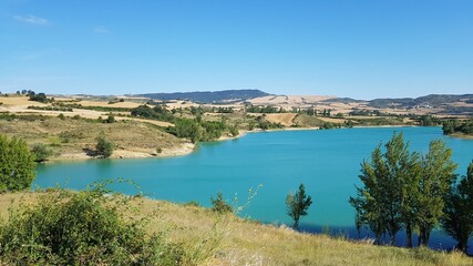 Fototapeta na wymiar un bonito y tranquilo lago de montañas con agua azul limpia y cielo azul en España
