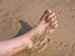 Pie de niña con arena en la playa
