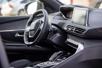Fototapeta na wymiar Dark luxury car interior. Black leather multifunctional steering wheel, start and stop engine buttom, dashboard, steering wheel and driver seat