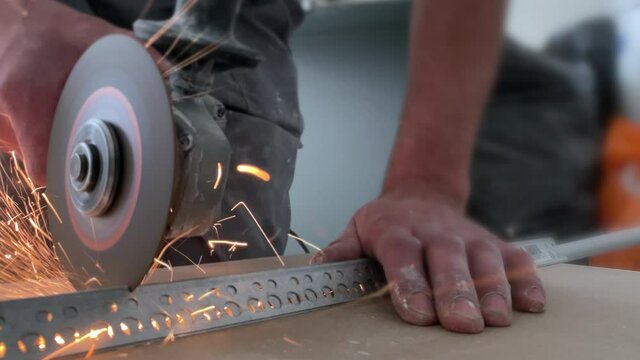 Cutting metal profile with a grinder during repair work. Lots of friction sparks