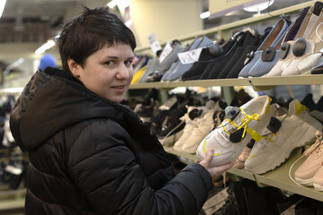 Beautiful young girl looking at shoes. Casual women's shoes