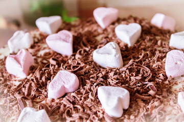 Festive cake with cream and chocolate, decorated with hearts.