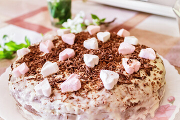 Festive cake with cream and chocolate, decorated with hearts.