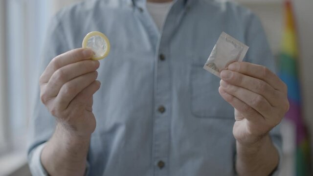 Responsible man holding condom closeup, hiv awareness, conscious family planning