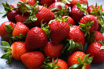 Beautiful fresh strawberries in a plate on a concrete background.