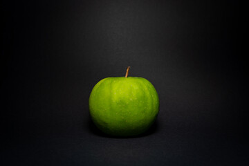 Green tasty apple on black background