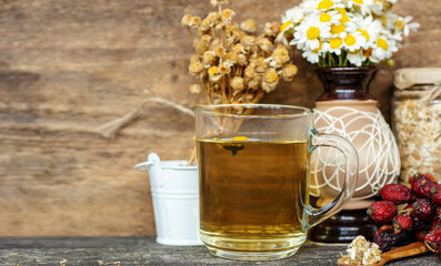 cup of herbal chamomile tea with fresh daisy flowers background, treatment and prevention of immune...