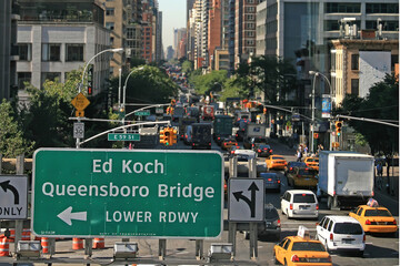 New York, USA. August 2012. Large Queensboro Bridge sign on East 59 street against a traffic jam in...