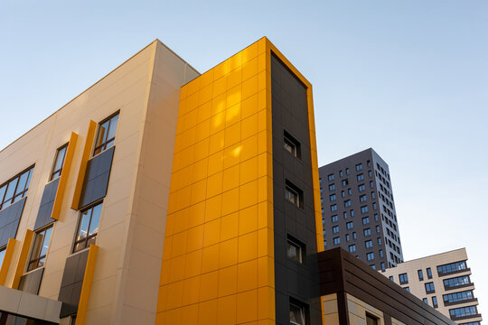Yellow-brown modern ventilated facade. Fragment of a new elite residential building or commercial complex. Part of urban real estate.